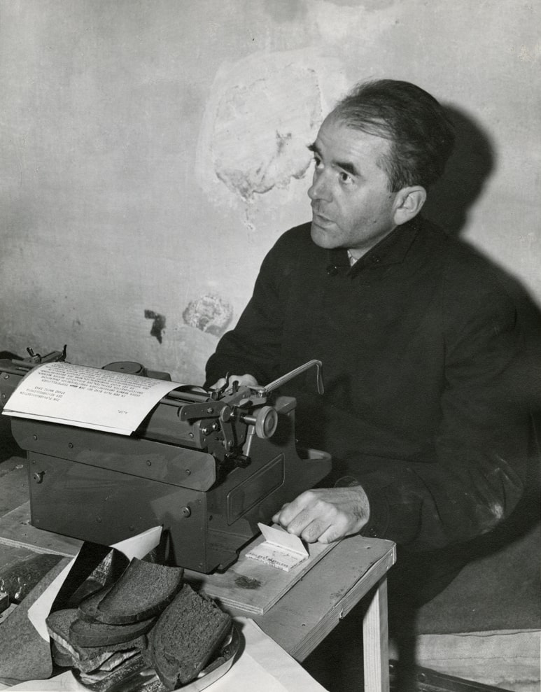 Albert Speer in his jail cell after WWII, with typewriter and a plate of bread.