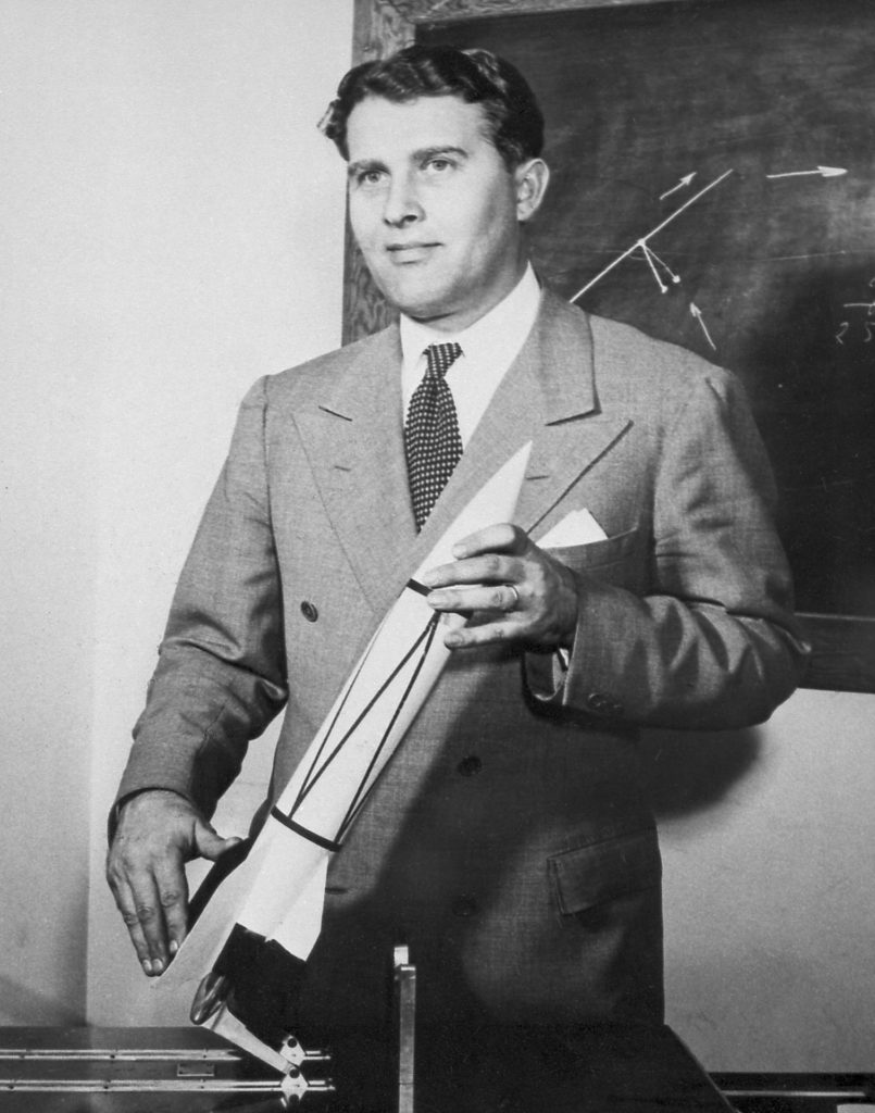 Werhher von Braun holding a model rocket.